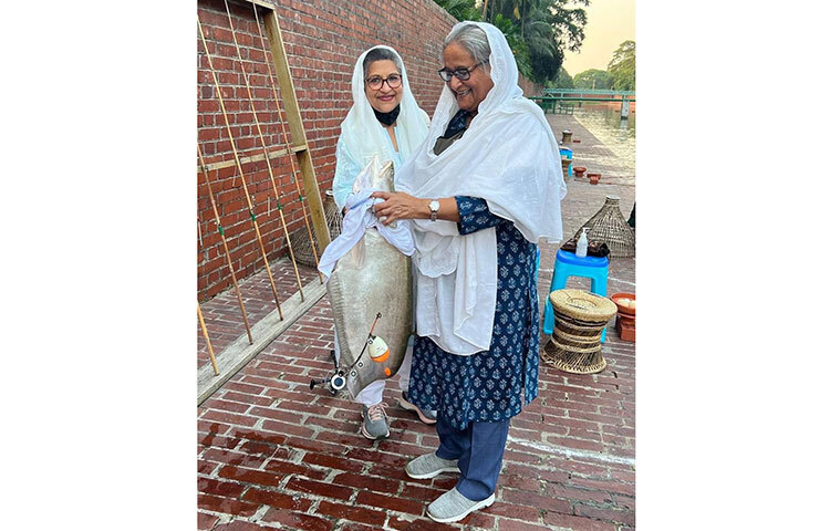 প্রধানমন্ত্রী শেখ হাসিনার হাতে মাছ শিকারের বড়শি। তাতে ধরা পড়েছে বড় আকারের একটি চিতল মাছ। সেই মাছ বড়শি থেকে ছাড়াচ্ছেন বঙ্গবন্ধুকন্যা শেখ হাসিনা ও তার ছোট বোন শেখ রেহানা। পরক্ষণে মাছ হাতে দুই বোনের উচ্ছ্বাস। ছবি: সংগৃহীত