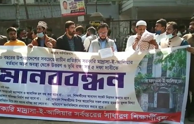 সরকারি মাদরাসা-ই-আলিয়া প্রাঙ্গণে বাংলাদেশ মাদরাসা ও কারিগরি শিক্ষা অধিদপ্তরের ভবন নির্মাণ, হল ও মাদরাসা অনির্দিষ্টকালের জন্য বন্ধের প্রতিবাদে মানববন্ধন করেছেন শিক্ষার্থীরা। আজ মাদরাসার প্রশাসনিক অফিসের সামনে তারা এ কর্মসূচি পালন করেন। এসময় দ্রুত ক্যাম্পাস খুলে দেওয়া ও প্রিন্সিপালের পদত্যাগের দাবি জানান শিক্ষার্থীরা। ছবি: মাহবুব আলম