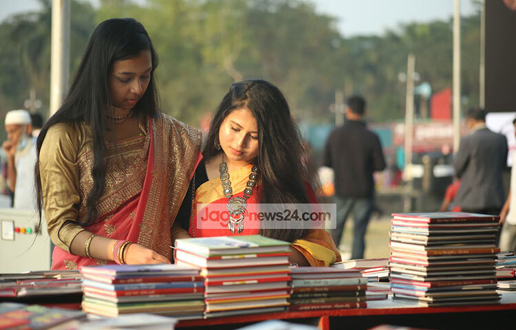 পছন্দের বই সংগ্রহের জন্য দুই পাঠক একটি স্টলে বই বাছাই করছেন। ছবি: মাহবুব আলম