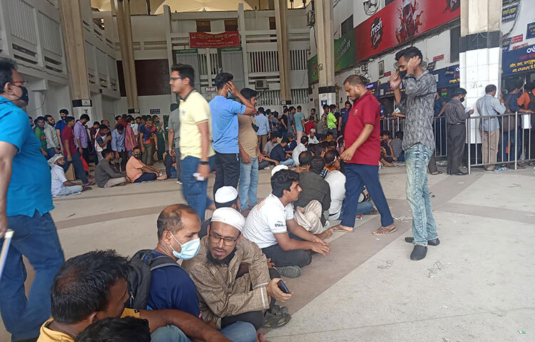 কেউ কেউ ট্রেনের টিকিট না পেয়ে বসে পড়েন কমলাপুর রেলওয়ে স্টেশনের মেঝেতে। ছবি: মাহবুব আলম