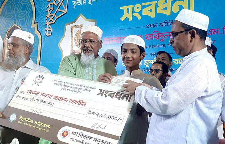 তাকরীমের হাতে ২ লাখ টাকার একটি চেক ও ক্রেস্ট তুলে দেন ধর্ম প্রতিমন্ত্রী মো. ফরিদুল হক খান। আজ বেলা ১১টার দিকে জাতীয় মসজিদ বায়তুল মোকাররমে এ সংবর্ধনা দেওয়া হয়। ছবি: জাগো নিউজ
