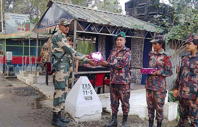 বর্ডারগার্ড বাংলাদেশ (বিজিবি) দিবস উপলক্ষে দিনাজপুরে হিলি সীমান্তের চেকপোস্টে ভারতীয় সীমান্তরক্ষী বাহিনীকে মিষ্টি উপহার দিয়ে শুভেচ্ছা বিনিময় করেছে জয়পুরহাট-২০ বিজিবি। আজ বেলা ১১টায় হিলি সীমান্তের ২৮৫ নম্বর মেইন পিলারের ১১ নম্বর সাব পিলার সংলগ্ন চেকপোস্ট গেটের শূন্যরেখায় এ মিষ্টি বিনিময় করা হয়। ছবি: জাগো নিউজ