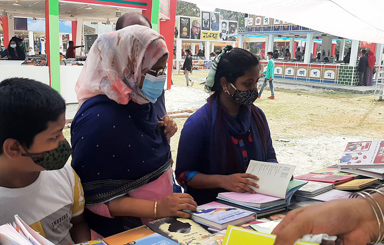 বাংলা একাডেমির আয়োজনে চলছে অমর একুশে বইমেলা। আজ মেলার দ্বিতীয় দিন। একটি স্টলে বই দেখছেন বইপ্রেমীরা। ছবি: জাগো নিউজ