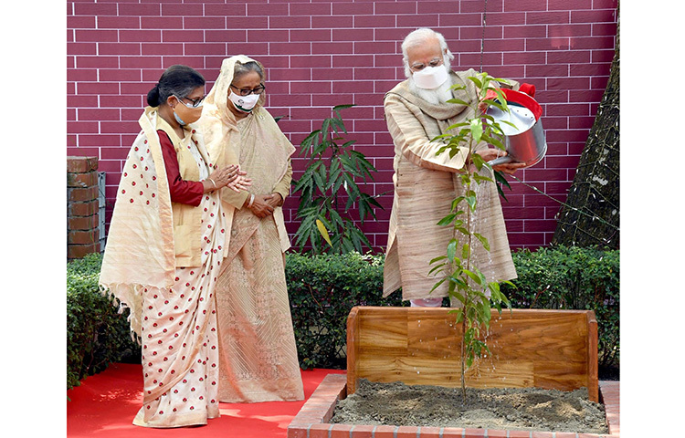 ভারতের প্রধানমন্ত্রী নরেন্দ্র মোদি টুঙ্গিপাড়ায় জাতির পিতা বঙ্গবন্ধু শেখ মুজিবুর রহমানের স্মৃতিসৌধ কমপ্লেক্সে বকুল গাছের চারা রোপণ করেন। এ সময় তার সঙ্গে ছিলেন প্রধানমন্ত্রী শেখ হাসিনা ও তার ছোট বোন শেখ রেহানা। ছবি: পিআইডি