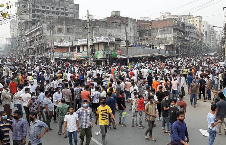 নিউমার্কেট এলাকার রাস্তায় নেমে লকডাউনের বিরুদ্ধে প্রতিবাদ করছেন ব্যবসায়ীরা। ছবি: জাগো নিউজ