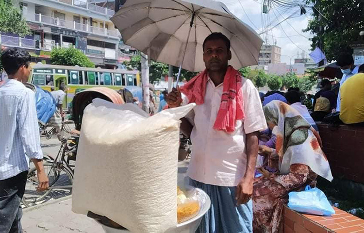 দীর্ঘদিন পর আবারও স্কুলে সামনে খাবার বিক্রি করতে পেরে আনন্দিত তিনি এই বিক্রেতা। ছবি: জাগো নিউজ