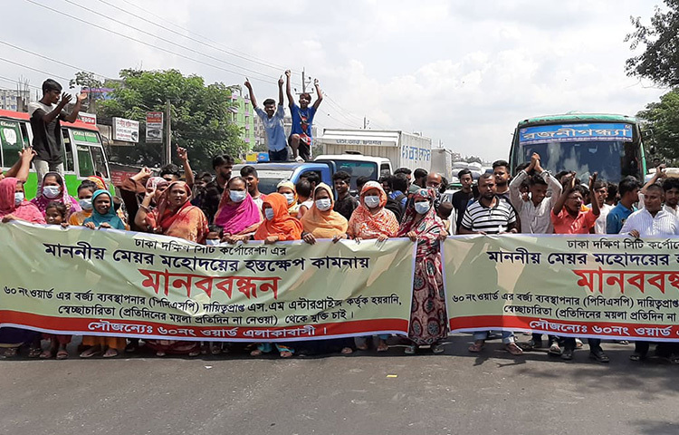 রাজধানীর যাত্রাবাড়ীর শনির আখড়া এলাকায় বর্জ্য নিয়ে বাণিজ্যের প্রতিবাদে মানববন্ধন করেছেন ঢাকা দক্ষিণ সিটি করপোরেশনের ৬০ নম্বর ওয়ার্ডের বাসিন্দারা। আজ শনির আখড়ায় ঢাকা-চট্টগ্রাম মহাসড়কে মানববন্ধন করেন তারা। ছবি: মাহবুব আলম
