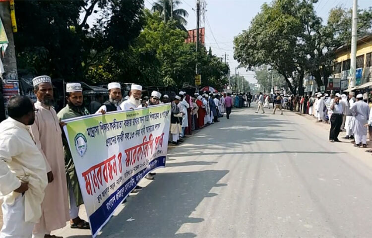 নড়াইলে স্বতন্ত্র শিক্ষাক্রম ও পাঠ্যপুস্তক প্রণয়নসহ ১৩ দফা দাবি বাস্তবায়নে মানববন্ধন করেছে মাদরাসার শিক্ষক ও কর্মচারীরা। বাংলাদেশ জমিয়াতুল মোদার্রেছীনের ব্যানারে আজ সকালে নড়াইল-যশোর সড়কের চৌরাস্তায় মানববন্ধন করেন তারা। এতে জেলার তিনটি উপজেলার বিভিন্ন মাদরাসার শিক্ষক-কর্মচারীরা অংশ নেন। পরে নড়াইল জেলা প্রশাসক মোহাম্মদ হাবিবুর রহমানের মাধ্যমে প্রধানমন্ত্রীর কাছে স্মারকলিপি দেওয়া হয়। ছবি: জাগো নিউজ