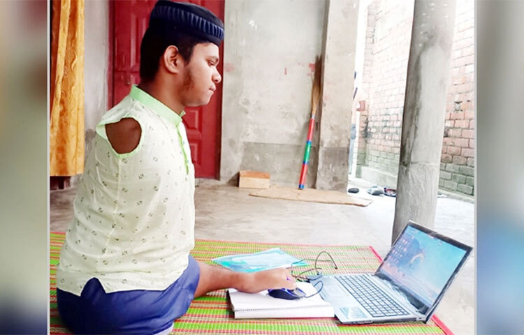 দুই হাত নেই। ডান পা নেই, বাম পা রয়েছে, তাও আবার স্বাভাবিকের চেয়ে অনেক ছোট। পায়ের আঙুলের ফাঁকে কলম রেখে দাখিল পরীক্ষায় অংশগ্রহণ করা অদম্য প্রতিবন্ধী রাসেল মৃধা পাস করেছে। নাটোরের সিংড়া উপজেলার শোলাকুড়া ইসলামিয়া আলিম মাদরাসা থেকে এবছর দাখিল পরীক্ষায় জিপিএ-৩ দশমিক ৮৮ পেয়ে উত্তীর্ণ হয়েছে রাসেল। ছবি: রেজাউল করিম