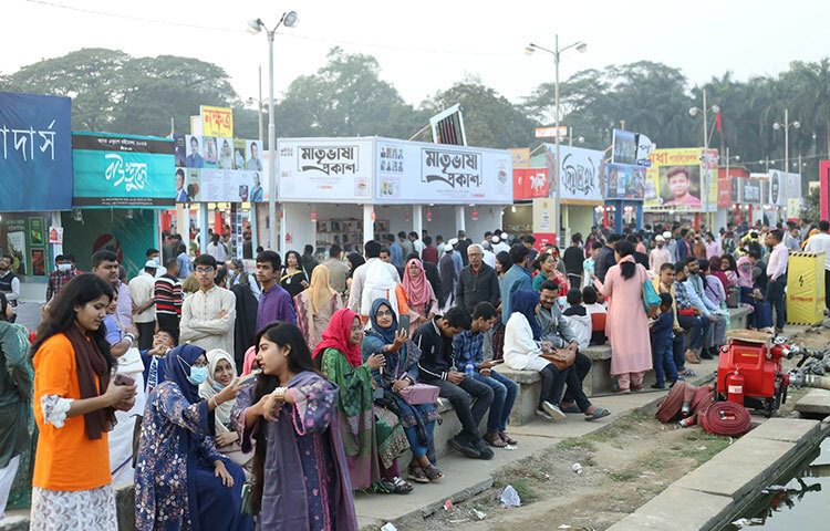 বইমেলায় ঘুরে ঘুরে ক্লান্ত হয়ে বিশ্রাম নিচ্ছেন কেউ কেউ। আবার কেউ বা বইমেলায় আসার প্রিয় মুহূর্তটিকে স্থির চিত্রে ধরে রাখতে চাইছেন। ছবি: মাহবুব আলম