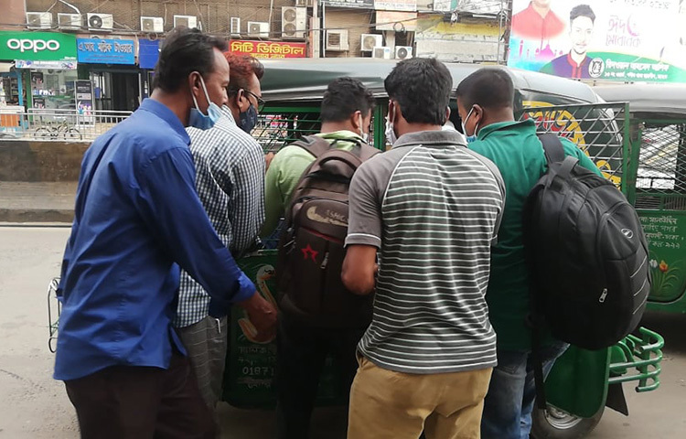 একটি সিএনজিকে ঘিরে ছয়জন মানুষ। তারা প্রত্যেকেই নিজ নিজ গন্তব্যে যাওয়ার জন্য সিএনজিটি ভাড়া নিতে চাইছেন। লকডাউনের এ সময় রাজধানীর বিভিন্ন সড়কে এমন দৃশ্য দেখা যাচ্ছে। ছবি: বিপ্লব দিক্ষিৎ