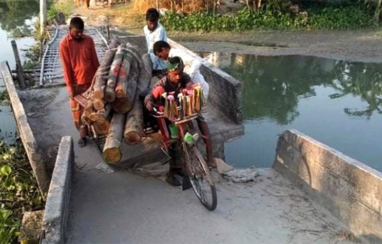 নীলফামারীর ডিমলা উপজেলার খগারচর এলাকায় তিস্তা নদীর ওপর নির্মিত সেতুটির বেহাল দশা। সেতুটির দুই পাশ দেবে গিয়ে মাঝ বরাবর আঁকাবাঁকা হয়ে গেছে। নদী পারাপারের বিকল্প রাস্তা না থাকায় সেতুর দুই প্রান্তে বাঁশের সাঁকো তৈরি করে জীবনের ঝুঁকি নিয়ে চলাচল করছেন ১৯ গ্রামের বাসিন্দারা। অনেক সময় দুর্ঘটনাও ঘটছে। ছবি: জাগো নিউজ