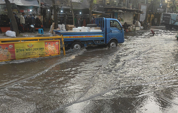 স্থানীয় বাসিন্দারা জানান, আজ ভোররাতে সার্ক ফোয়ারার এরিয়া দেয়ালে ফাটল দেখা দেয়। তখন থেকেই ফাটলের অংশে পানি গড়িয়ে পড়তে থাকে। দিনভর পানি গড়িয়ে জলাবদ্ধতার সৃষ্টি হলেও তা সমাধান করেনি ওয়াসা কর্তৃপক্ষ। ছবি: বিপ্লব দিক্ষিৎ