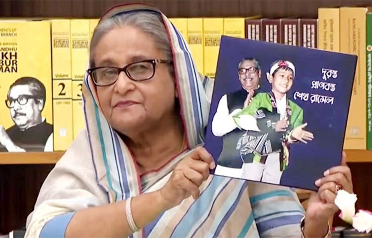 জাতির পিতা বঙ্গবন্ধু শেখ মুজিবুর রহমানের ছোট ছেলে শেখ রাসেলের জন্মদিন উপলক্ষে প্রকাশিত হয়েছে ‘দুরন্ত প্রাণবন্ত শেখ রাসেল’ শীর্ষক স্মারকগ্রন্থ। আজ সকালে প্রধানমন্ত্রী শেখ হাসিনা বইটির মোড়ক উন্মোচন করেন। এর আগে বঙ্গবন্ধু আন্তর্জাতিক সম্মেলন কেন্দ্রে ‘শেখ রাসেল দিবস’ উদ্বোধন ও ’শেখ রাসেল পদক’ প্রদান অনুষ্ঠানে সংযুক্ত হন প্রধানমন্ত্রী। গণভবন থেকে ভিডিও কনফারেন্সের মাধ্যমে যুক্ত হন তিনি। ছবি: জাগো নিউজ