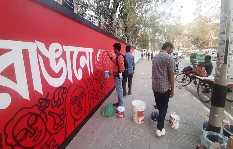 একুশে ফেব্রুয়ারি উপলক্ষে দেয়াল লিখনে ব্যস্ত সময় কাটছে চারুকলার শিক্ষার্থীদের। ছবি: বিপ্লব দিক্ষিৎ
