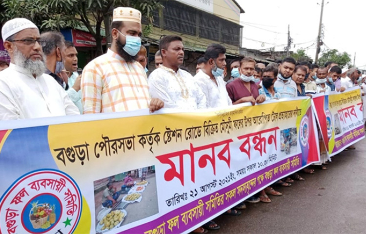 বগুড়া পৌরসভায় মৌসুমী ফলের উপর আরোপিত টোল প্রত্যাহারের দাবি জানিয়েছেন ব্যবসায়ীরা। আজ শহরের স্টেশন রোডে ঘণ্টাব্যাপী মানববন্ধন করেন সহস্রাধিক পাইকারি ও খুচরা ফল ব্যবসায়ী। ছবি: জাগো নিউজ