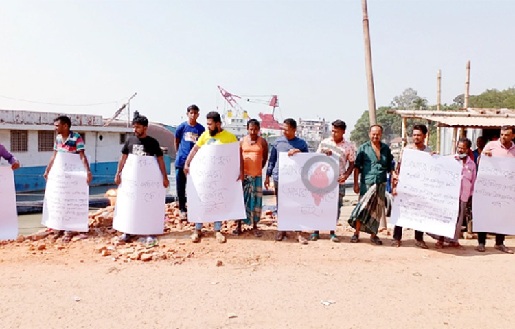 পাটুরিয়া ঘাটে ডুবে যাওয়া ফেরিতে থাকা গাড়ির মালিক, চালক ও হেলপাররা ক্ষতিপূরণের দাবিতে মানববন্ধন করেছেন। আজ পাটুরিয়ার ৫ নম্বর ফেরিঘাটে অ্যাপ্রোচ সড়কে এ কর্মসূচি পালন করেন তারা। এসময় তাদের হাতে বিভিন্ন দাবি সংবলিত প্ল্যাকার্ড দেখা যায়। ছবি: জাগো নিউজ
