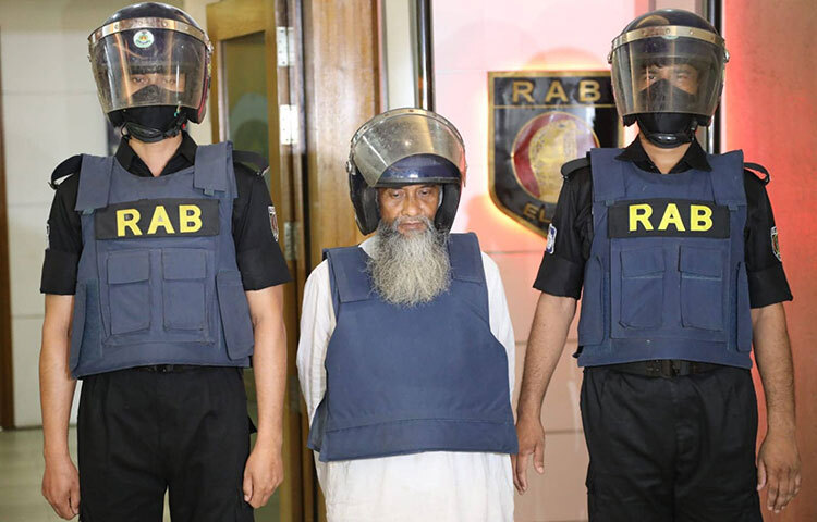 বহুল আলোচিত রমনা বটমূলে বোমা হামলায় মৃত্যুদÐপ্রাপ্ত ও একাধিক মামলার পলাতক আসামি মুফতি শফিকুর রহমান নিজের নাম-পরিচয় পরিবর্তন করে দীর্ঘ ২১ বছর ধরে আত্মগোপনে ছিলেন। আজ দুপুরে কারওয়ান বাজারের র‌্যাব মিডিয়া সেন্টারে আয়োজিত এক সংবাদ সম্মেলনে এ তথ্য জানান লিগ্যাল অ্যান্ড মিডিয়া উইংয়ের পরিচালক কমান্ডার খন্দকার আল মঈন। ছবি: জাগো নিউজ