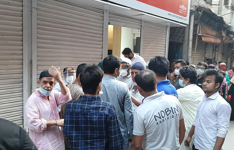 ভলান্টিয়ার কয়েকজনের তদারকিতে সুশৃঙ্খলভাবে সকলেই এগিয়ে যাচ্ছেন এবং তাদের হাতে একটি করে ইফতারের প্যাকেট তুলে দেয়া হচ্ছে। সাদা পাঞ্জাবি পায়জামা পরিহিত এক যুবকসহ কয়েকজন কার্ড দেখে দেখে ইফতারি তুলে দিচ্ছেন। ছবি: জাগো নিউজ