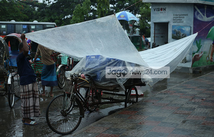 পলিথিন দিয়ে নিজের অস্থায়ী ভ্যানগাড়ির দোকান বৃষ্টি থেকে রক্ষার জন্য চেষ্টা করছেন এ দোকানি। ছবি: মাহবুব আলম