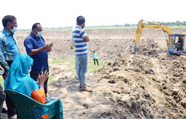 নাটোরের লালপুর উপজেলার বিলশলিয়া এলাকায় সরকারি এক কর্মকর্তা ও তার পরিবার কর্তৃক খাসজমি দখল ও পানি প্রবাহের ব্রিজ সংলগ্ন স্থানে খননকৃত পুকুর ভরাট শুরু হয়েছে। ছবি: সংগৃহীত