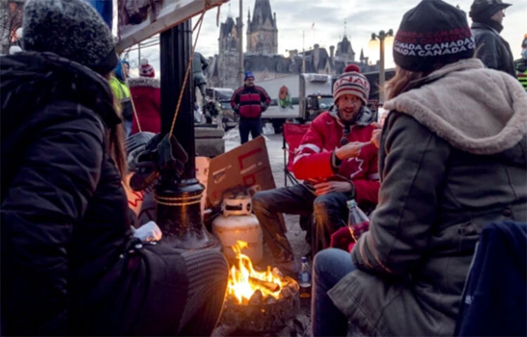 কানাডার রাজধানী অটোয়ায় করোনা বিধিনিষেধের বিরুদ্ধে এখনো চলছে আন্দোলন। দেশটির ট্রাকচালকরা এ আন্দোলন দীর্ঘ সময় চালিয়ে যাবেন বলে ধারণা করা হচ্ছে। ট্রাকচালকরা এরই মধ্যে শহরের ট্রাফিক ব্যবস্থা বন্ধ করে দিয়েছে ও তাঁবু খাটিয়ে অবরোধ করে রেখেছে রাস্তা। ছবি: সংগৃহীত