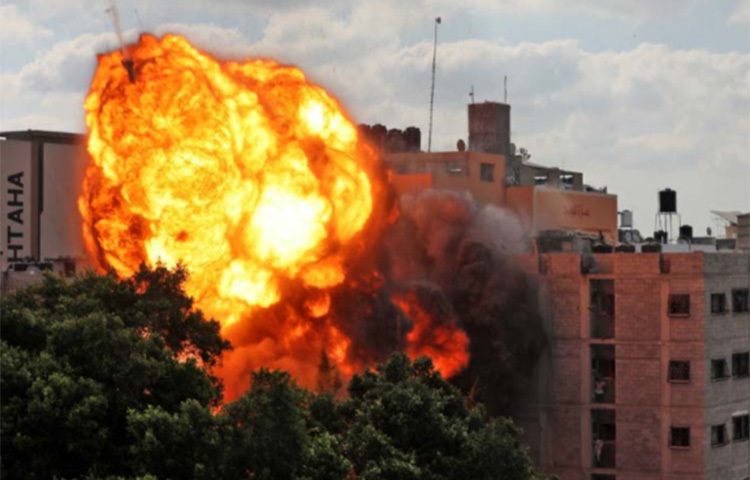 গাজা শহরে ইসরায়েলি বিমান বাহিনীর হামলায় ধসে পড়ার আগে আল-ওয়ালিদ বিল্ডিংয়ে অগ্নিকুণ্ডলী। ছবি: এএফপি