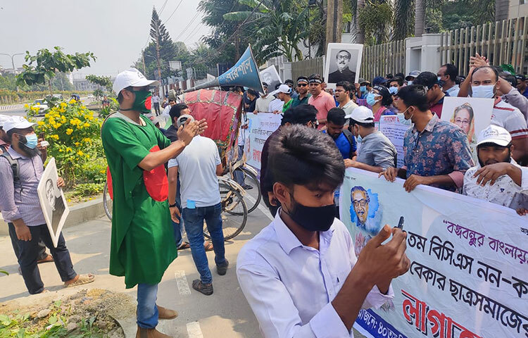 ৪০তম বিসিএস পরীক্ষায় উত্তীর্ণ নন-ক্যাডার তালিকায় থাকা অপেক্ষমাণ প্রার্থীরা সরকারকে ৬ দফা দাবি জানিয়েছেন। এসব দাবি মানা না হলে আমরণ অনশনের ঘোষণা দিয়েছেন তারা। আজ সকাল ১০টা থেকে পিএসসির গেটে ৬ দফা দাবি নিয়ে লাগাতার অবস্থান কর্মসূচিতে অংশ নিয়েছেন নন-ক্যাডার তালিকায় থাকা অপেক্ষমাণ প্রার্থীরা। ছবি: বিপ্লব দিক্ষিৎ