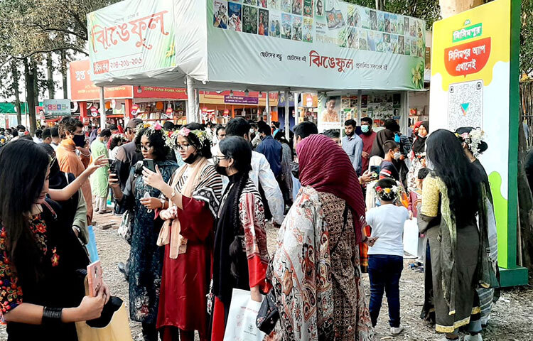 মেলার মাঠে সেলফি তুলছেন তারা। ছুটির দিন থাকায় পরিবারের সকলকে নিয়ে তারা বইমেলায় এসেছেন। ছবি: সংগৃহীত
