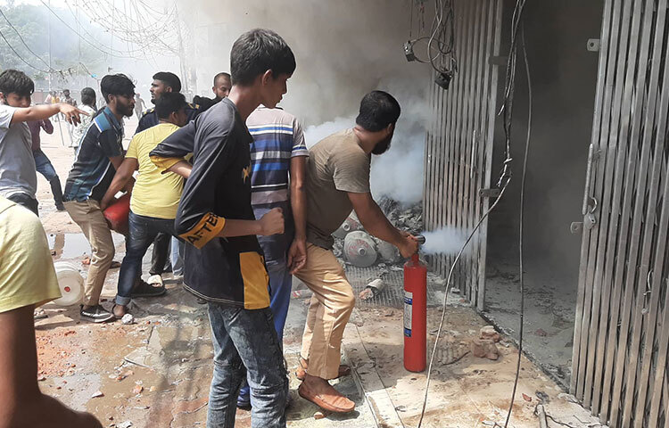 আগুন নিয়ন্ত্রণে আনার চেষ্টা করছেন নিউমার্কেটের শ্রমিকরা। ছবি: বিপ্লব দিক্ষিৎ