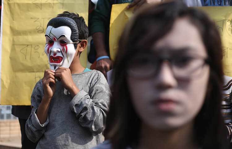 মুখোশ পড়ে প্রতিবাদ। ছবি: মাহবুব আলম