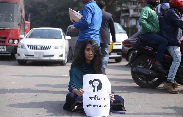 ‘নারী প্রতি সহিংসতা বন্ধ কর’ প্রতিবাদে প্লাকার্ড নিয়ে রাস্তায় বসেছে এক ছাত্রী। গতকাল রোববার সন্ধ্যায় কুর্মিটোলায় বিশ্ববিদ্যালয়ের বাস থেকে নেমে যাওয়ার পর তাকে তুলে নিয়ে ধর্ষণ করা হয় বলে অভিযোগ করেন ওই ছাত্রী। ছবি: মাহবুব আলম