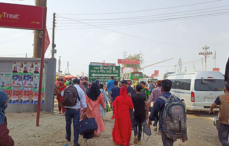 শিমুলিয়া ফেরিঘাটে মানুষের ঢল। প্রখর রোদের মাঝেও কারো যেনো কোনো ক্লান্তি নেই। ছবি: বাদল খান