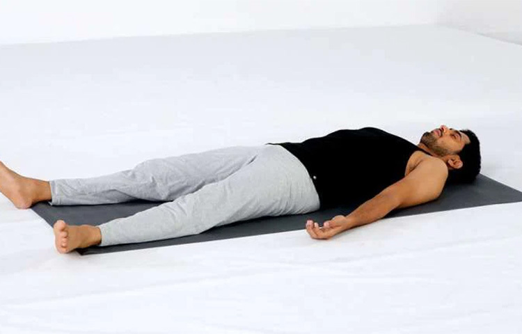 শবাসন, প্রথম ধাপ: চিৎ হয়ে শুয়ে পড়তে হবে। পা থাকবে সোজা। হাত থাকবে শরীরের পাশে। দ্বিতীয় ধাপ: হাত ও পা শিথিল রাখতে হবে। হাতের তালু থাকবে উপরের দিকে। তৃতীয় ধাপ: এবার চোখ বন্ধ করে স্বাভাবিক শ্বাস-প্রশ্বাস চালিয়ে যেতে হবে। ছবি: সংগৃহীত