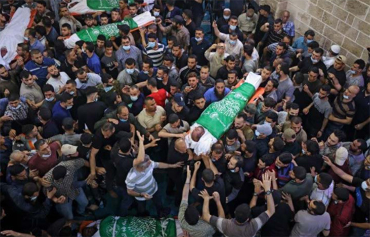 গাজায় ইসরায়েলি বিমান হামলায় নিহত ১৩ জনের মরদেহ নিয়ে ফিলিস্তিনিরা প্রতিবাদ জানাচ্ছেন। ছবি: এএফপি