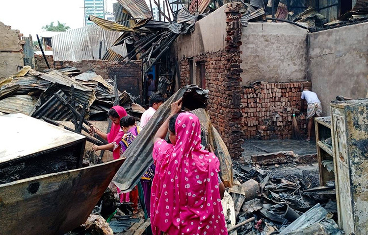 পুড়ে যাওয়া ঘর পরিষ্কার করছেন বস্তির লোকজন। ছবি: জাগো নিউজ