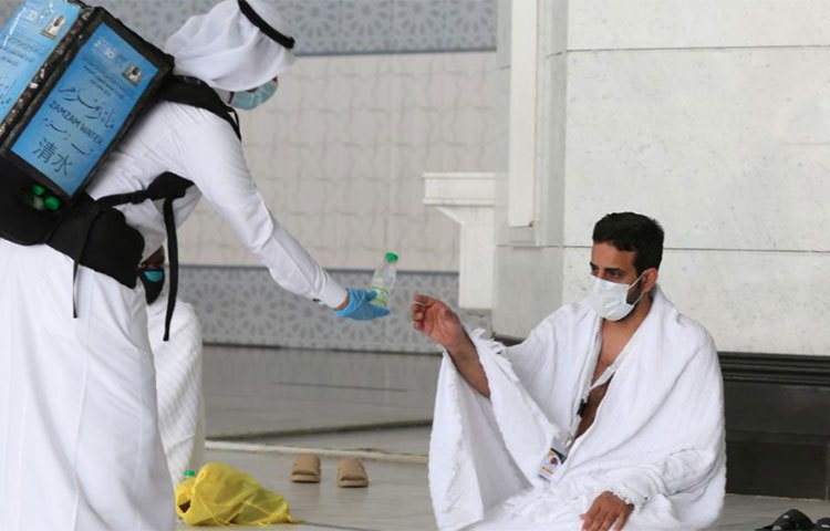 সৌদি কর্তৃপক্ষ এক হজ পালনকারীকে স্বাস্থ্য সুরক্ষাসামগ্রী প্রদান করেছেন। ছবি: সিএনএন