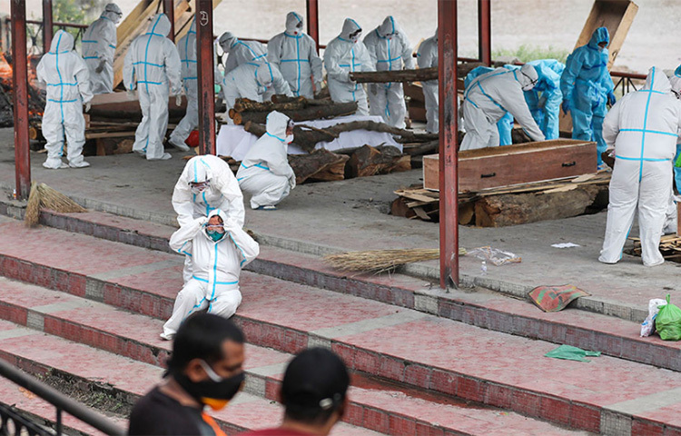 স্বাস্থ্যকর্মী এবং মৃতের পরিজনরা পিপিই পরেছেন। স্বজন হারানোর এই ছবি জম্মুর। ছবি: সংগৃহীত