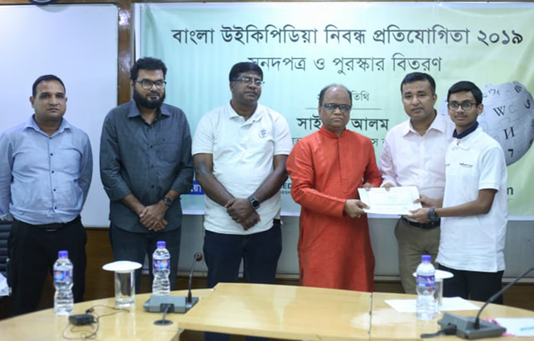 প্রতিযোগিতায় বিজয়ী এক প্রতিযোগীকে পুরস্কার প্রদান করা হচ্ছে। অনুষ্ঠানে প্রধান অতিথির বক্তব্যে জাতীয় প্রেস ক্লাবের সভাপতি সাইফুল আলম বলেন, ‘আমি এখানে এসে সমৃদ্ধ হয়েছি। আমরা কিছু জানি, অনেক কিছু জানি না। আমি আশান্বিত হয়েছি এখানে উপস্থিত সবাই কম সময়ে অনেক কথা বলেছেন। আমরা শুরু করতে জানি, শেষ করি না। আপনারা যারা শুরু করেছেন, আশা করি তা বিস্তৃত হবে।’ ছবি: মাহবুব আলম