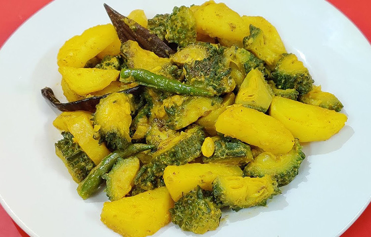 এবার নারিকেল ও সরিষা দিয়ে করলা রান্নার জন্য প্রথমে করলা ভেজে তুলে রাখুন। কড়াইতে তেল গরম হলে, সমস্ত মশলা মিশিয়ে কষাতে থাকুন। এবার করলা ভাজা, নারিকেল মিশিয়ে ওপরে সরিষার তেল ছড়িয়ে মিনিট দুয়েক আঁচে রেখে নামিয়ে নিন। ছবি: সংগৃহীত