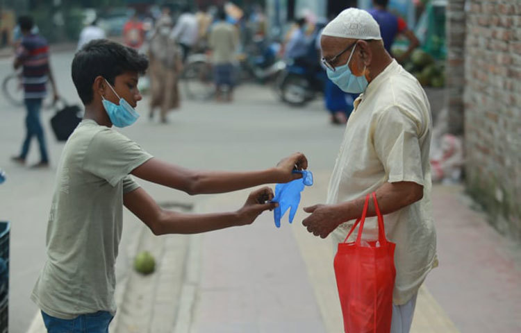 করোনার থেকে বাঁচার সুরক্ষা সামগ্রী বিক্রি করছে এই কিশোরা। ছবি: মাহবুব আলম
