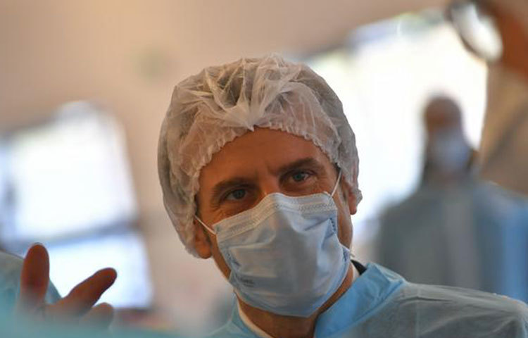 ছবিতে প্রেসিডেন্ট এমানুয়েল মাক্রোঁকে দেখা যাচ্ছে। সম্প্রতি তিনি মাস্ক ও নিরাপত্তা পোশাক তৈরি করে এমন এক কারখানা পরিদর্শনে গিয়েছিলেন। তবে সে দেশের অনেক ডাক্তার পর্যাপ্ত মাস্ক ও নিরাপত্তা পোশাক না পাওয়ায় সরকারের বিরুদ্ধে মামলা করেছেন।