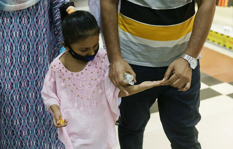 শিশুটির হাতে হ্যান্ড সেনিটাইজার দিয়ে দেয়া হচ্ছে। ছবি: মাহবুব আলম