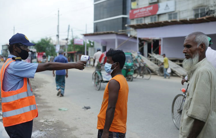 গরুর হাটে প্রবেশের আগে সবার শরীরের তাপমাত্রা পরীক্ষা করা হচ্ছে। ছবি: মাহবুব আলম