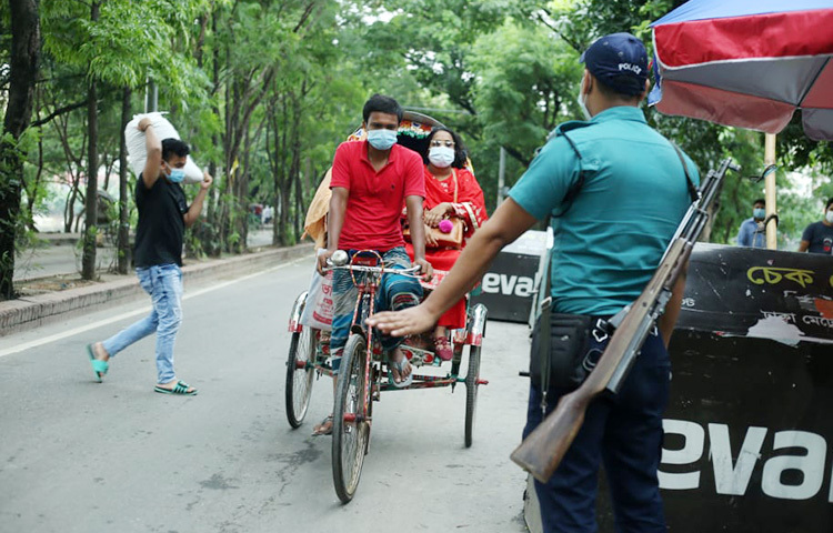 পথে পথে এভাবে আটকে দিচ্ছে পুলিশ। রিকশার যাত্রীদের কাছে জানতে চাইছে বাইরে বের হওয়ার কারণ। ছবি: মাহবুব আলম
