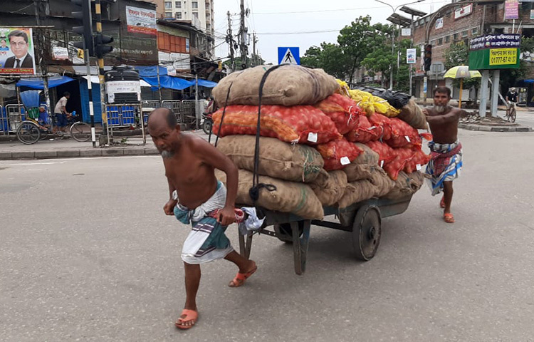 আলু, পিয়াজ দোকানে নিয়ে যাচ্ছেন শ্রমিকরা। ছবি: বিপ্লব দিক্ষিৎ