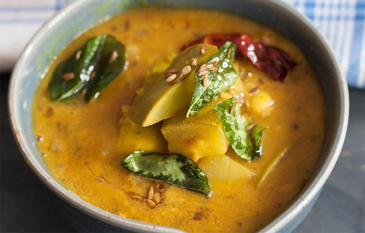 আম ডাল: কাঁচা আম খোসা ছাড়িয়ে আঁটি বাদ দিয়ে ডুমো ডুমো করে কেটে রাখতে হবে। গরম পানিতে সামান্য তেল ও হলুদ দিয়ে সেদ্ধ করে নিতে হবে। কিন্তু খেয়াল রাখতে হবে ডাল যেন পুরো গলে না যায়। কড়াইয়ে তেল গরম হলে কালো সরিষা ও শুকনো ফোড়ন দিয়ে নেড়েচেড়ে আমের টুকরোগুলো দিতে হবে। ডালে হলুদ লবণ ও চিনি দিয়ে কিছুক্ষণ ফুটতে দিতে হবে আমের সঙ্গে। ছবি: সংগৃহীত