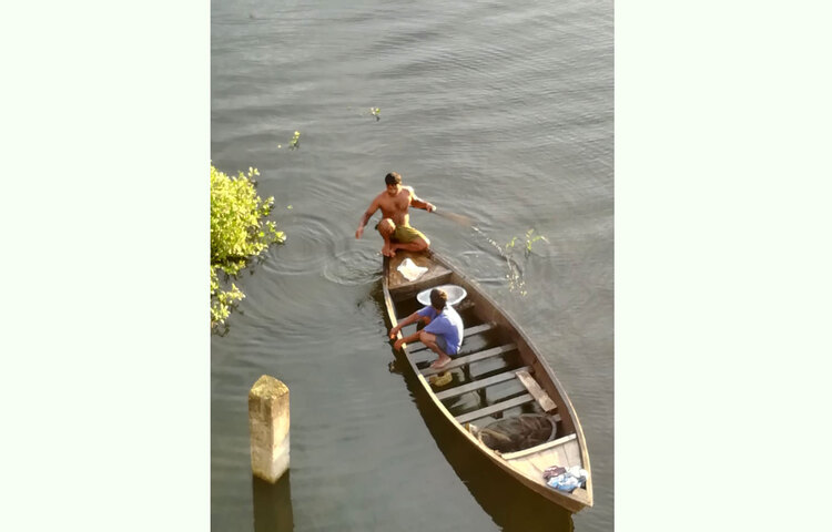 জলাশয়ের বদ্ধজলে নৌকায় মাছ ধরছেন তারা। ছবি: এস. এম. মাছুম বিল্লাহ