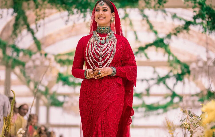 লাল ব্লাউজ ও সারিতে সেজেছিলেন নয়নতারা। গলায়, হাতে ও মাথায় সবুজ পাথর বসানো গয়না পরেছিলেন। অন্য দিকে ঘিয়ে রঙা কুর্তি ও মুন্ড ছিল বরের পরনে। ছবি: সংগৃহীত