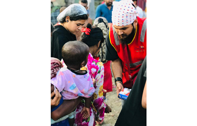 সারিবদ্ধ হয়ে নোবেলের হাত থেকে খাবার নিচ্ছে পথশিশুরা।